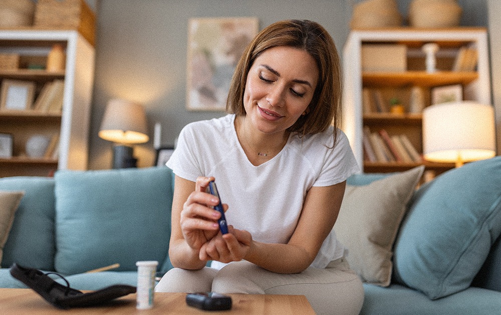A young woman with diabetes doing an at-home blood sugar test with a glucometer. 