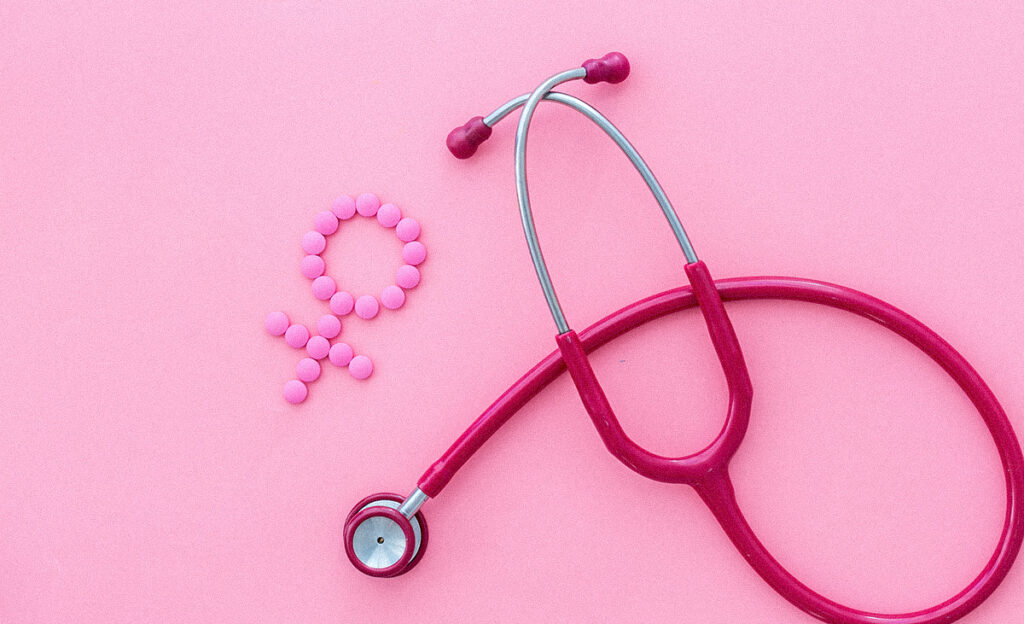 Problèmes de santé féminine. Concept médical avec signe de Vénus et stéthoscope sur fond rose de haut en bas.