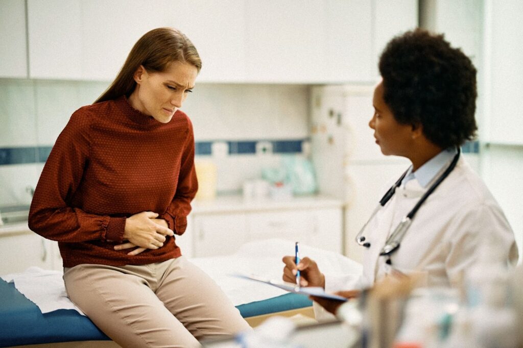 Woman in an examination with a doctor due to abdominal, pelvic pain. 