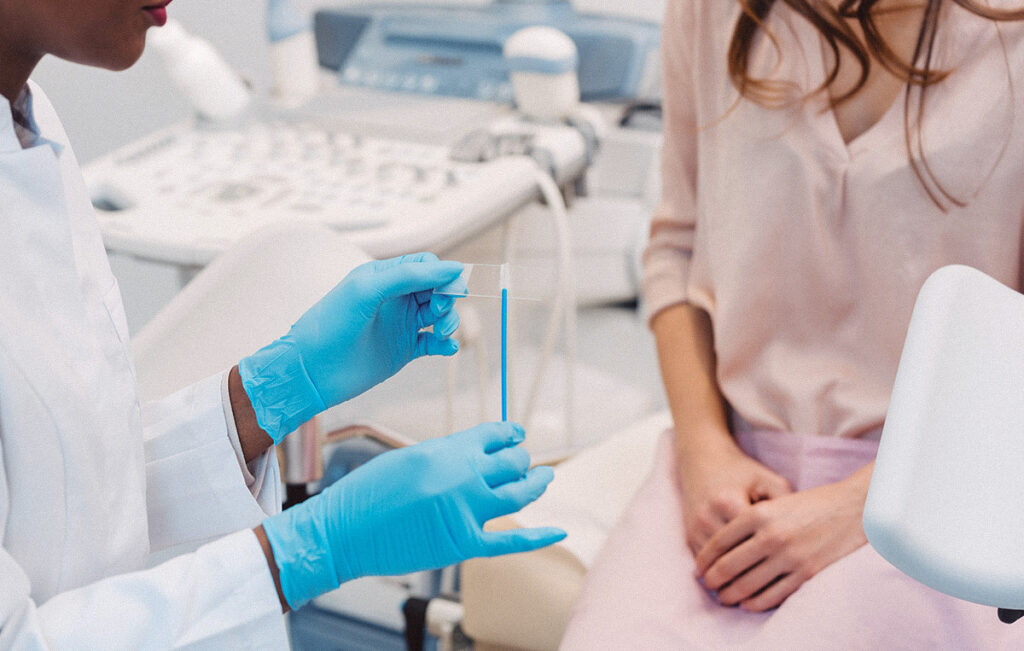 Femme assise dans le bureau d'un médecin avec un gynécologue pour passer un test ITS.