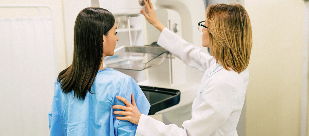 Jeune femme passant une mammographie dans une clinique privée en présence d'une femme médecin.