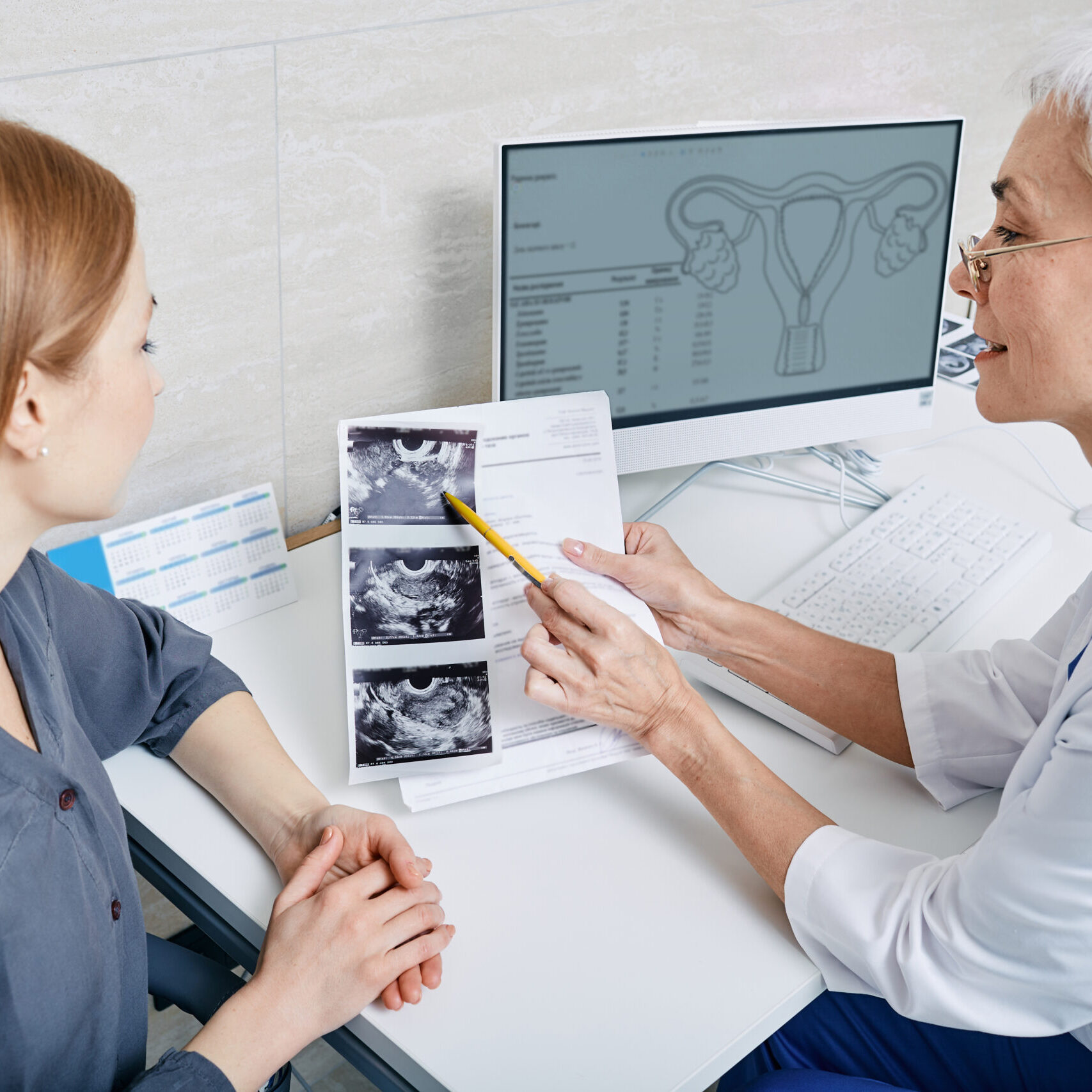 Gynecologist showing woman ultrasound of her ovaries during female patient visit to gynecology. Gynecology, consultation of gynecologist, women's health.