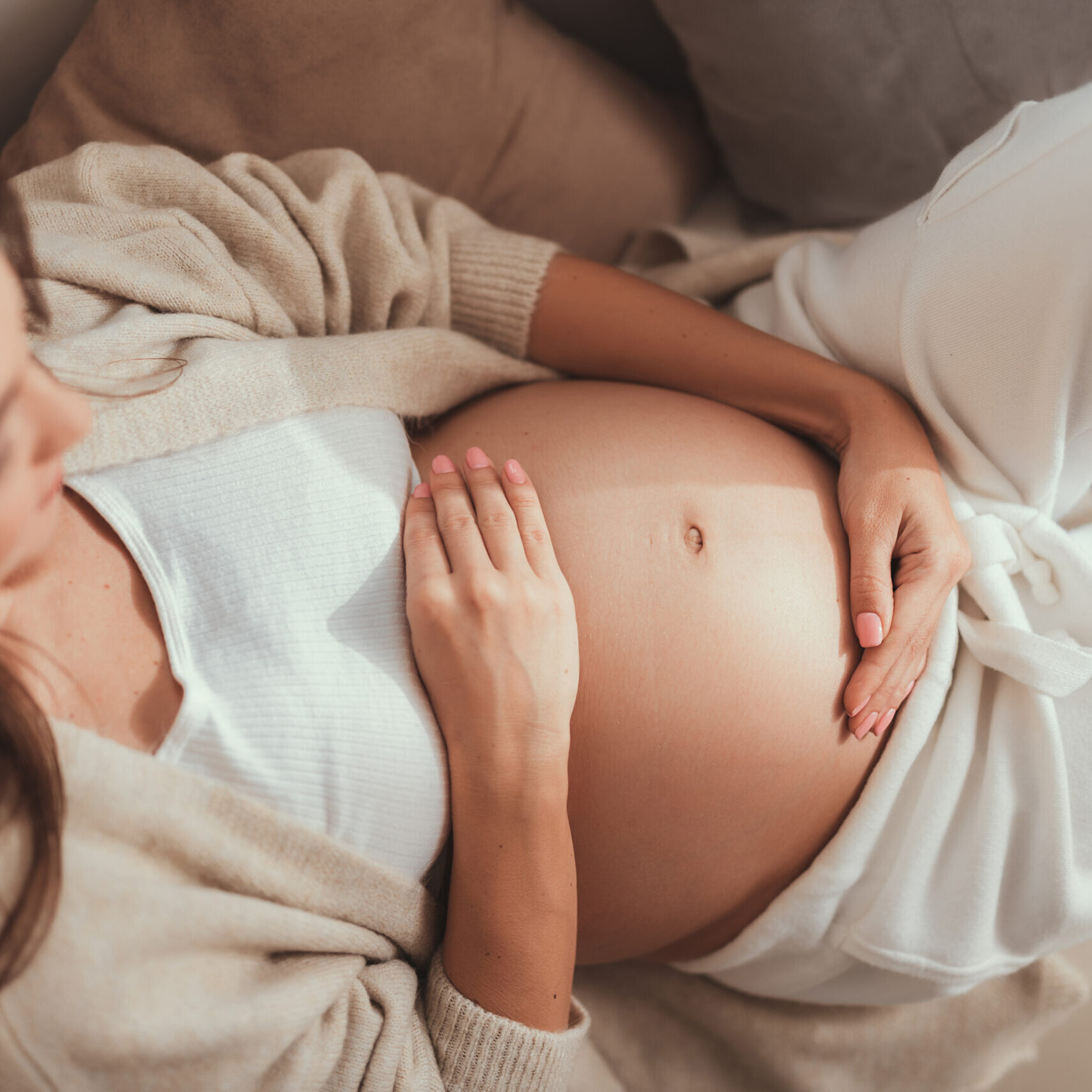 High angle above top view beautiful attractive pretty expectant mother on third trimester lying on cozy couch inside bright flat