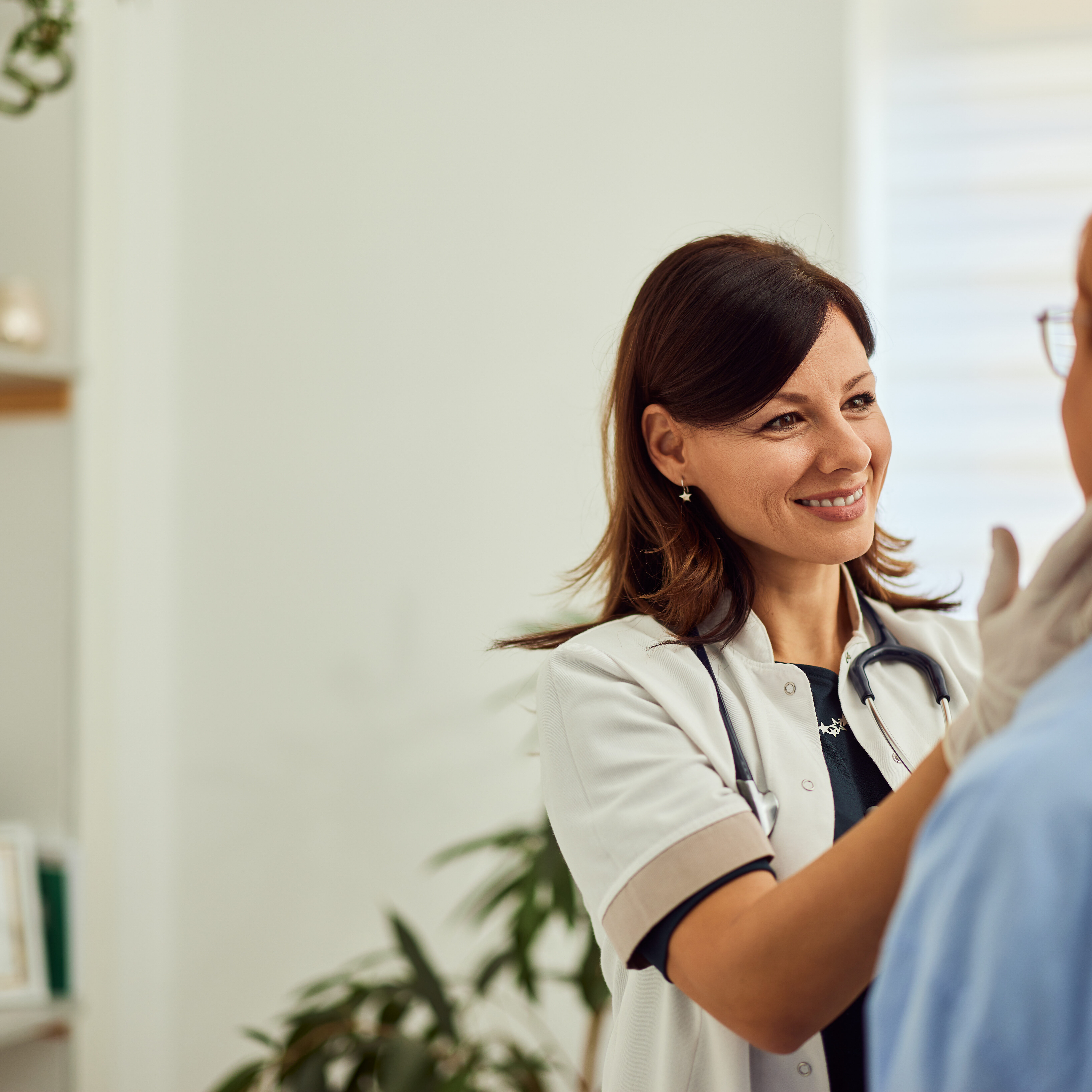 A smiling doctor, dressed in a doctor's uniform, having thyroid gland control.
