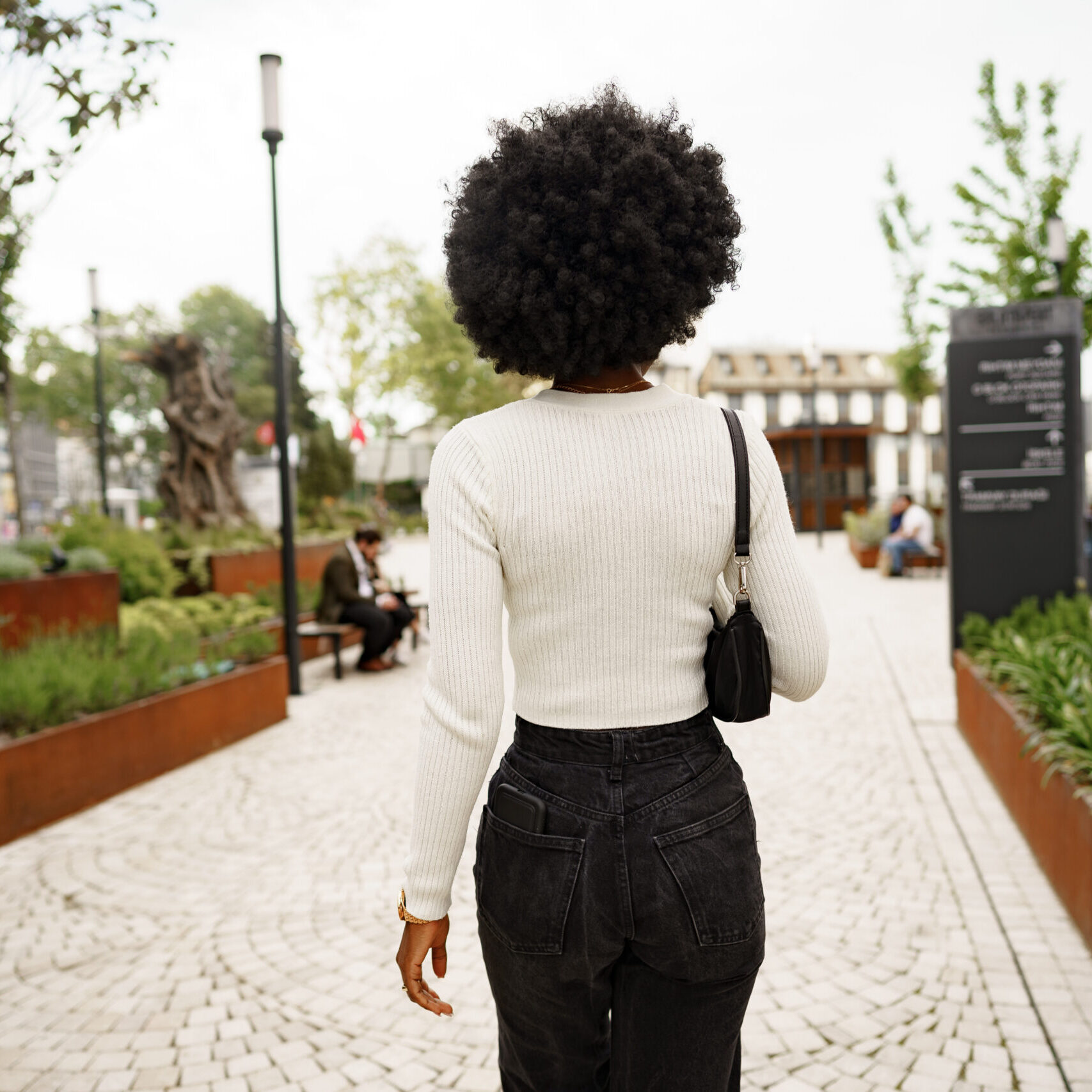 Back view of african woman walking in city center